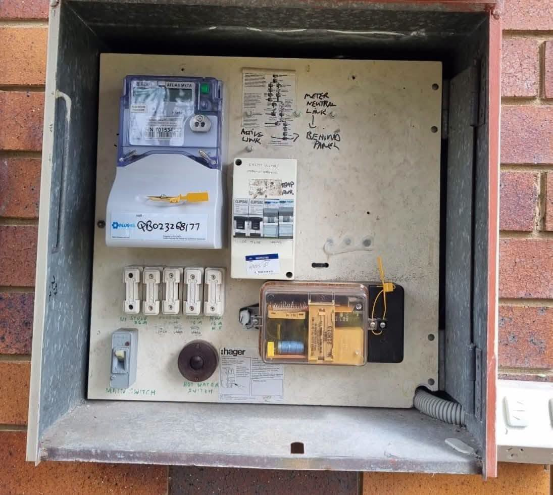 Older residential switchboard with ceramic fuses requiring professional electrical inspection